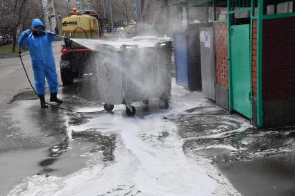 Москва.  Сотрудник коммунальной службы в защитном костюме во время дезинфекции улиц.