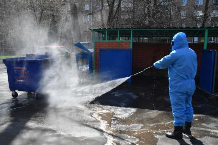 Москва.  Сотрудник коммунальной службы в защитном костюме во время дезинфекции улиц.