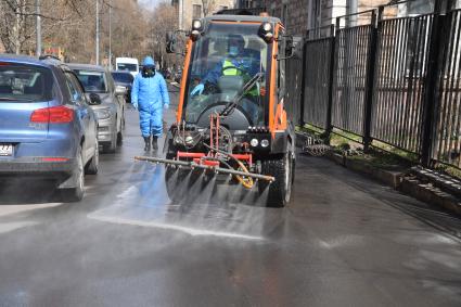 Москва.   Автомобиль коммунальной службы моет улицу.