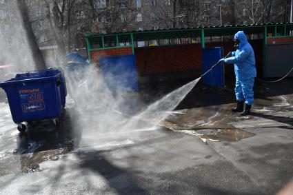 Москва.  Сотрудник коммунальной службы в защитном костюме во время дезинфекции улиц.