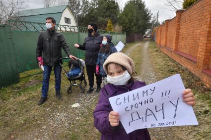 Московская область.  Девочка держит в руках объявление о съеме дачи в период режима самоизоляции из-за пандемии коронавируса.