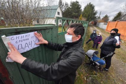 Московская область. Мужчина расклеивает объявление о съеме дачи в период режима самоизоляции из-за пандемии коронавируса.