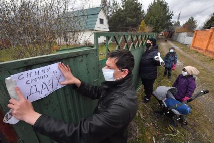 Московская область. Мужчина расклеивает объявление о съеме дачи в период режима самоизоляции из-за пандемии коронавируса.