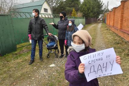 Московская область.  Девочка держит в руках объявление о съеме дачи в период режима самоизоляции из-за пандемии коронавируса.