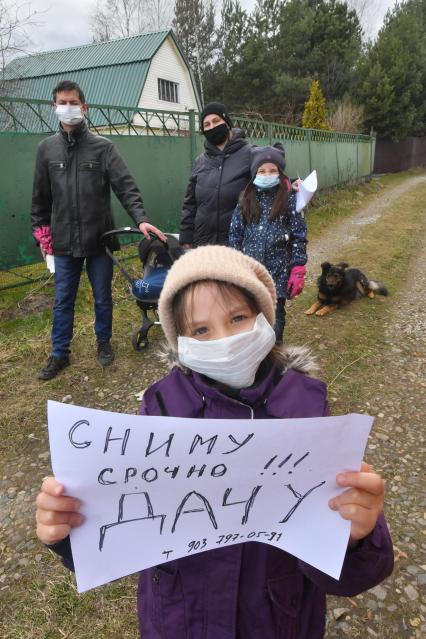 Московская область.  Девочка держит в руках объявление о съеме дачи в период режима самоизоляции из-за пандемии коронавируса.