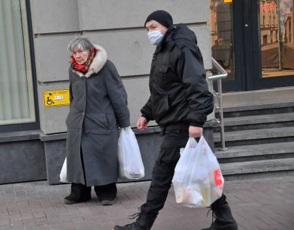 Москва. Пожилая женщина и мужчина выходят из магазина.