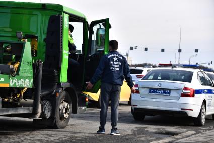 Москва. Сотрудник дорожно-патрульной службы ГИБДД во время проверки электронного пропуска у водителя на блокпосту при въезде в Москву.