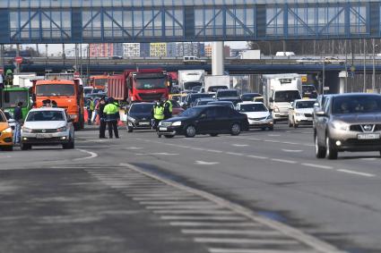 Москва. Сотрудник дорожно-патрульной службы ГИБДД во время проверки электронного пропуска у водителя на блокпосту при въезде в Москву.