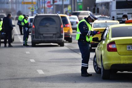 Москва. Сотрудник дорожно-патрульной службы ГИБДД во время проверки электронного пропуска у водителя на блокпосту при въезде в Москву.