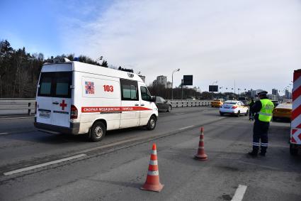 Москва. Сотрудник дорожно-патрульной службы ГИБДД во время проверки электронного пропуска у водителя на блокпосту при въезде в Москву.