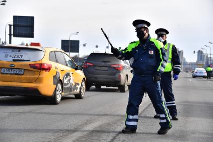 Москва. Сотрудник дорожно-патрульной службы ГИБДД во время проверки электронного пропуска у водителя на блокпосту при въезде в Москву.