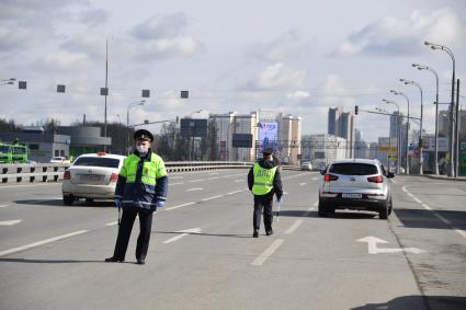 Москва. Сотрудник дорожно-патрульной службы ГИБДД во время проверки электронного пропуска у водителя на блокпосту при въезде в Москву.