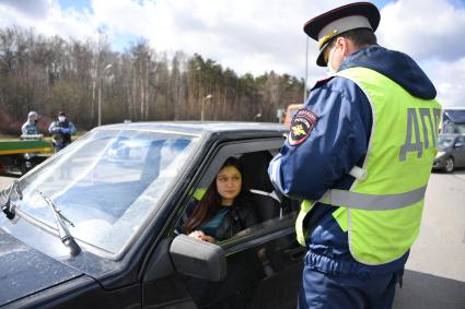 Москва. Сотрудник дорожно-патрульной службы ГИБДД во время проверки электронного пропуска у водителя на блокпосту при въезде в Москву.