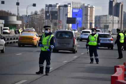 Москва. Сотрудник дорожно-патрульной службы ГИБДД во время проверки электронного пропуска у водителя на блокпосту при въезде в Москву.