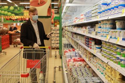 Иркутск. Волонтер в продуктовом магазине покупает продукты для пенсионеров.