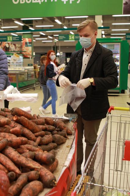 Иркутск. Волонтер в продуктовом магазине покупает продукты для пенсионеров.