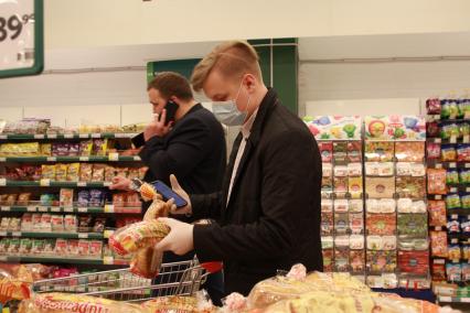 Иркутск. Волонтер в продуктовом магазине покупает продукты для пенсионеров.