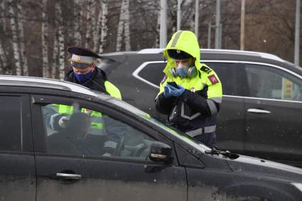 Москва.  Полицейский проверяет пропуск у водителя.