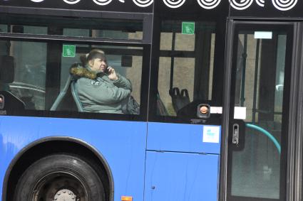 Москва.  Женщина в общественном транспорте  разговаривает по мобильному телефону.