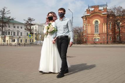 Иркутск.   Молодожены в медицинских масках во время прогулки.