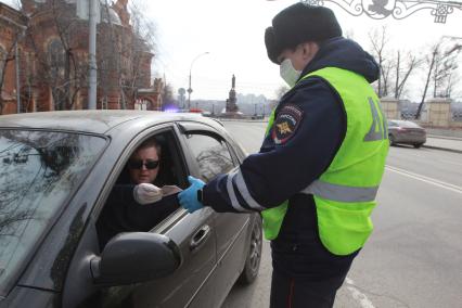 Иркутск.  Инспектор ДПС проводит проверку документов у водителей во время эпидемии коронавируса.