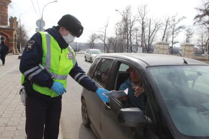 Иркутск.  Инспектор ДПС проводит проверку документов у водителей во время эпидемии коронавируса.