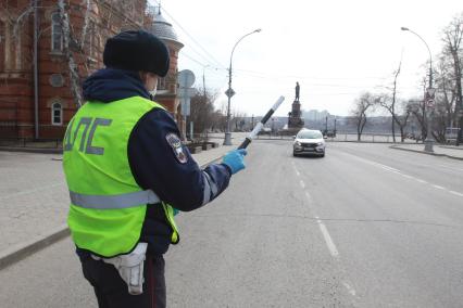 Иркутск.  Инспектор ДПС проводит проверку документов у водителей во время эпидемии коронавируса.