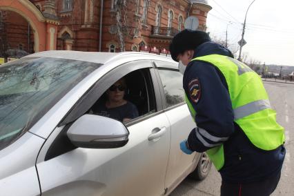 Иркутск.  Инспектор ДПС проводит проверку документов у водителей во время эпидемии коронавируса.