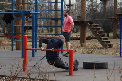 Иркутск.  Мужчины занимаются на спортивной площадке.