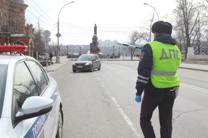 Иркутск. Инспектор ДПС проводит проверку документов у водителей во время эпидемии коронавируса.