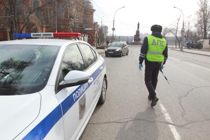 Иркутск.  Инспектор ДПС проводит проверку документов у водителей во время эпидемии коронавируса.