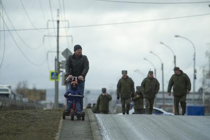 Екатеринбург. Мужчина с ребенком в медицинской маске во время проведения репетиции парада.