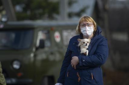 Екатеринбург. Женщина в медицинской маске и с собачкой ожидает проходы колонны военной техники учавствующей в репетиции парада.