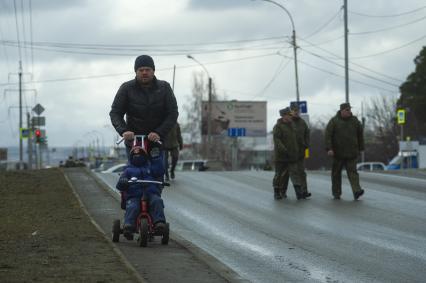 Екатеринбург. Мужчина с ребенком в медицинской маске во время проведения репетиции парада.