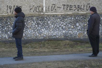 Екатеринбург. Двое мужсин стоят у дома с надписью \'Русский - трезвый\' во время эпидемии коронавирусной инфекции COVID-19