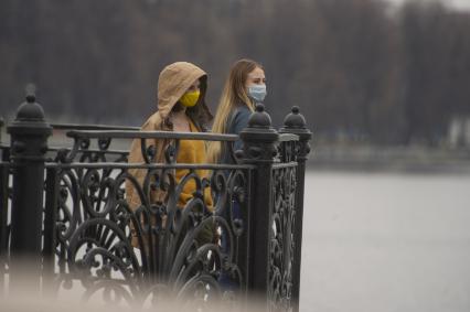 Екатеринбург. Девушки в медицинских масках гуляют по набережной городского пруда во время эпидемии коронавирусной инфекции COVID-19