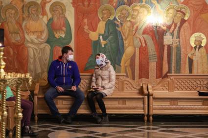 Иркутск. Мужчина и женщина в медицинских масках во время праздничного пасхального богослужения.