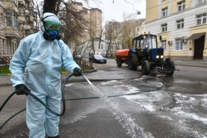 Москва. Сотрудник коммунальной службы проводит дезинфекцию внутридворовой территории .