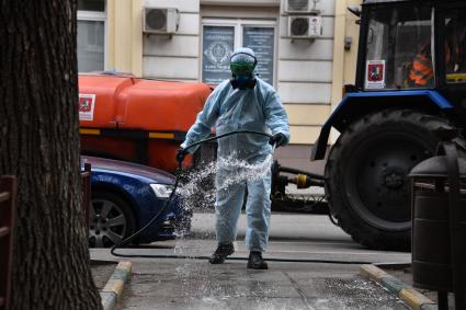 Москва. Сотрудник коммунальной службы проводит дезинфекцию внутридворовой территории .