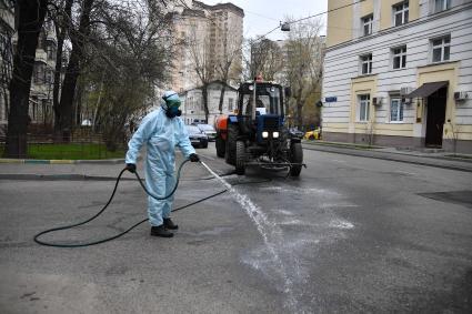 Москва. Сотрудник коммунальной службы проводит дезинфекцию внутридворовой территории .