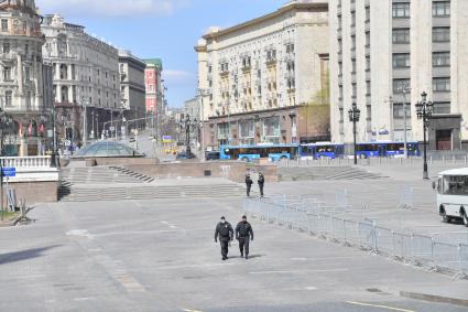 Москва. Сотрудники полиции в медицинских масках на пустой Манежной площади.