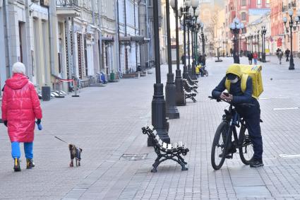 Москва. Сотрудник сервиса доставки еды в медицинской маске.