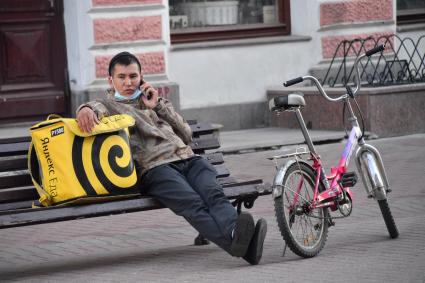 Москва. Сотрудник сервиса доставки еды в медицинской маске.