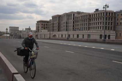 Москва. Сотрудник сервиса доставки еды на пустынной улице.