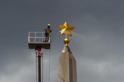 Санкт-Петербург. Сотрудник коммунальной службы моет  обелиск `Городу-герою Ленинграду` на площади Восстания.