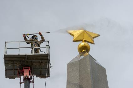 Санкт-Петербург. Сотрудник коммунальной службы моет  обелиск `Городу-герою Ленинграду` на площади Восстания.