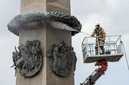 Санкт-Петербург. Сотрудник коммунальной службы моет  обелиск `Городу-герою Ленинграду` на площади Восстания.