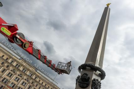 Санкт-Петербург. Сотрудник коммунальной службы моет  обелиск `Городу-герою Ленинграду` на площади Восстания.