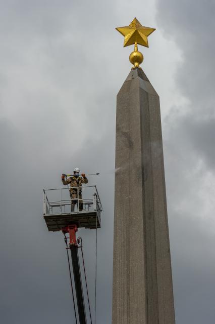 Санкт-Петербург. Сотрудник коммунальной службы моет  обелиск `Городу-герою Ленинграду` на площади Восстания.