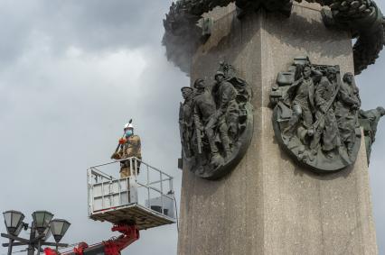 Санкт-Петербург. Сотрудник коммунальной службы моет  обелиск `Городу-герою Ленинграду` на площади Восстания.